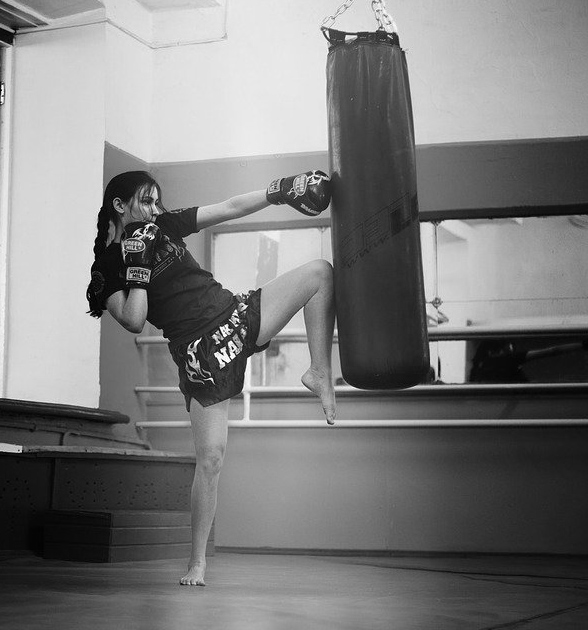 Frau beim Kick am Sandsack